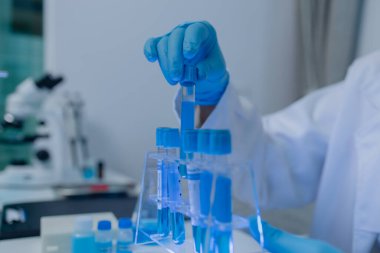 Bir kadın kimyager laboratuvarda çeşitli sıvı bileşiklerini test ediyor, bir bilim adamı laboratuvarda, laboratuarda, laboratuarda, deney tüpünde, bilimsel araştırmalar yapıyor.