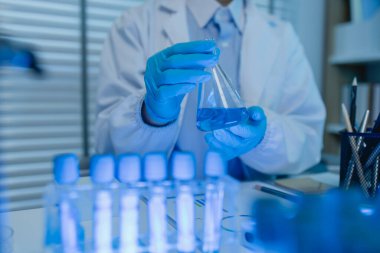 Bir kadın kimyager laboratuvarda çeşitli sıvı bileşiklerini test ediyor, bir bilim adamı laboratuvarda, laboratuarda, laboratuarda, deney tüpünde, bilimsel araştırmalar yapıyor.