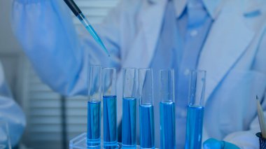 Bir kadın kimyager laboratuvarda çeşitli sıvı bileşiklerini test ediyor, bir bilim adamı laboratuvarda, laboratuarda, laboratuarda, deney tüpünde, bilimsel araştırmalar yapıyor.