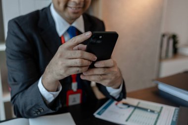 Bir işadamı yabancı bir şirketle iletişim kurar ve bilgi almak için akıllı telefon kullanır. Pazarlama müdürü, akıllı telefon aracılığıyla muhasebe bölümüne istatistik bilgileri gönderir.
