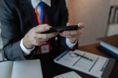Bir işadamı yabancı bir şirketle iletişim kurar ve bilgi almak için akıllı telefon kullanır. Pazarlama müdürü, akıllı telefon aracılığıyla muhasebe bölümüne istatistik bilgileri gönderir.