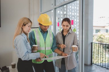 Mimarlar ve mühendisler gelecek binanın tasarımı ve yapısını ustabaşıyla tartışıyorlar. Detayları aynı sayfada anladıklarından emin olmak için. Beyin fırtınası, plan...