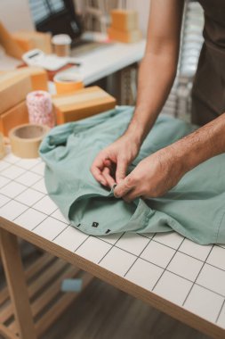 Küçük bir çevrimiçi işletme sahibi müşterilere göndermeden önce doğruluk için kutucukları işaretliyor, paket, bir çalışan müşterilere gönderilmek üzere ürünleri kutulara koyuyor