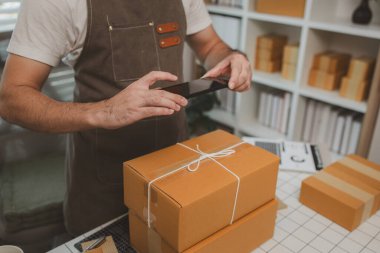 Paketleme odasındaki kutuları kontrol ediyor, küçük bir işletme sahibi kutuları müşterilere, ürünlere, e-ticarete, çevrimiçi satış ve ihracat şirketlerindeki girişimcilere göndermek için hazırlıyor.