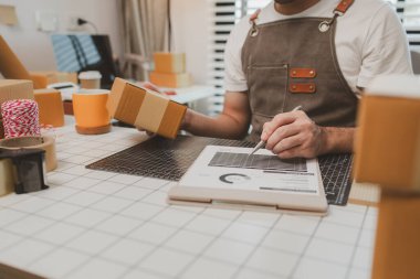 Paketleme odasındaki kutuları kontrol ediyor, küçük bir işletme sahibi kutuları müşterilere, ürünlere, e-ticarete, çevrimiçi satış ve ihracat şirketlerindeki girişimcilere göndermek için hazırlıyor.