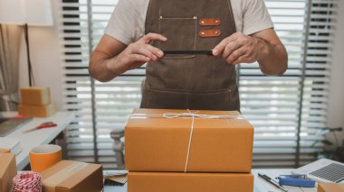 Paketleme odasındaki kutuları kontrol ediyor, küçük bir işletme sahibi kutuları müşterilere, ürünlere, e-ticarete, çevrimiçi satış ve ihracat şirketlerindeki girişimcilere göndermek için hazırlıyor.