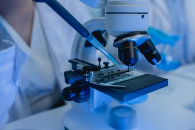 İki bilimadamı yeni bir antiviral ilaç bulmak için birlikte çalışıyor, iki kimyager bilim, mikroskop, laboratuvarda çalışmak için bilimsel araçlar kullanıyorlar,