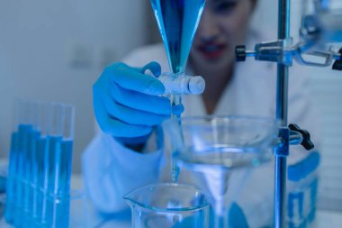 İki bilimadamı laboratuvarda sıvı madde üzerinde bir deney yaparken birbirlerine danışırlar, iki kimyager derleme, araştırma ve laboratuvar için deneysel veri alışverişinde bulunurlar.,