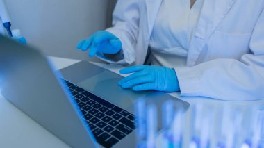 İki bilimadamı laboratuvarda sıvı madde üzerinde bir deney yaparken birbirlerine danışırlar, iki kimyager derleme, araştırma ve laboratuvar için deneysel veri alışverişinde bulunurlar.,