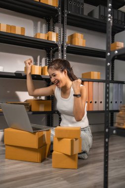 Küçük bir internet işletmesi sahibi, işi başarılı olduğu için kendini çok mutlu hissediyor. Girişimci, depo, paket, küçük işletme, neşe içinde olduğu süre zarfında neşesini gösteriyor.