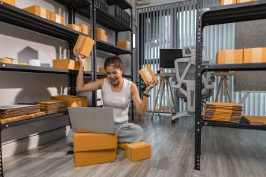 Küçük bir internet işletmesi sahibi, işi başarılı olduğu için kendini çok mutlu hissediyor. Girişimci, depo, paket, küçük işletme, neşe içinde olduğu süre zarfında neşesini gösteriyor.