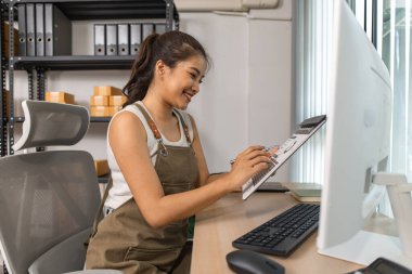 Depo müdürü verileri bilgisayara giriyor, bir çalışan depoda doğruluk için nakliye adreslerini kontrol ediyor, küçük bir işletme sahibi çevrimiçi bir iş deposunda çalışıyor.