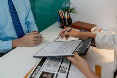 İnsan kaynakları müdürünün iş görüşmesine gelen yeni çalışanları var. Kontrat imzalayıp tam zamanlı çalışan oluyorlar. İnsan kaynakları ofisinde kontrat imzalıyorlar.