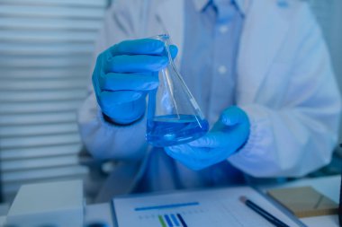 Bir kadın kimyager laboratuvarda çeşitli sıvı bileşiklerini test ediyor, bir bilim adamı laboratuvarda, laboratuarda, laboratuarda, deney tüpünde, bilimsel araştırmalar yapıyor.