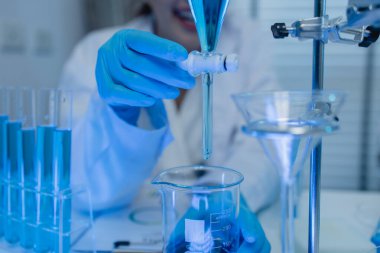 İki bilimadamı laboratuvarda sıvı madde üzerinde bir deney yaparken birbirlerine danışırlar, iki kimyager derleme, araştırma ve laboratuvar için deneysel veri alışverişinde bulunurlar.,