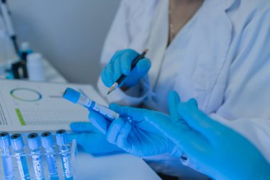 İki bilimadamı laboratuvarda sıvı madde üzerinde bir deney yaparken birbirlerine danışırlar, iki kimyager derleme, araştırma ve laboratuvar için deneysel veri alışverişinde bulunurlar.,