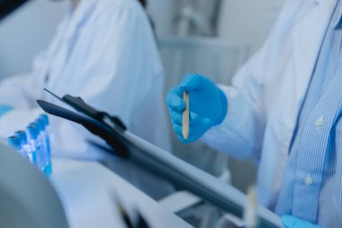 İki bilimadamı laboratuvarda sıvı madde üzerinde bir deney yaparken birbirlerine danışırlar, iki kimyager derleme, araştırma ve laboratuvar için deneysel veri alışverişinde bulunurlar.,