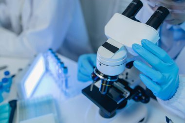 İki bilimadamı yeni bir antiviral ilaç bulmak için birlikte çalışıyor, iki kimyager bilim, mikroskop, laboratuvarda çalışmak için bilimsel araçlar kullanıyorlar,