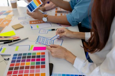 ux, ui, web ve mobil uygulama tasarımcıları, kullanıcılar için kolay ve keyifli hale getirmek için renk şemaları ve planlar da dahil olmak üzere tasarladıkları web sitesi veya uygulamanın görünüm ve hissini tartışıyor