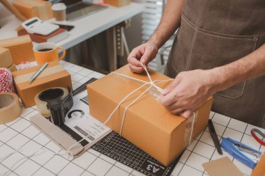 Çalışan, müşterilere nakliyeye hazırlanmak için ürünleri kutulara koyuyor, küçük bir online işletme sahibi müşterilere göndermeden önce doğruluk için kutucukları işaretliyor, paket,