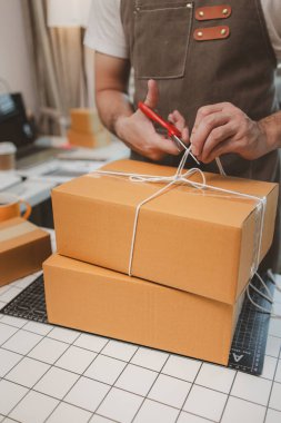 Çalışan, müşterilere nakliyeye hazırlanmak için ürünleri kutulara koyuyor, küçük bir online işletme sahibi müşterilere göndermeden önce doğruluk için kutucukları işaretliyor, paket,