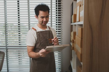 Bir işadamının çevrimiçi sattığı küçük bir iş yeri var. Online bir işletme sahibi paketi müşterilere, paketlere, girişimcilere, e-işletmelere göndermeden önce depodaki paketleri kontrol ediyor.