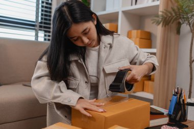 Tüm müşterilere göndermek için paket hazırlıyor. Bu girişimcinin küçük bir işletmesi var. Sme, internetten ürün satıyor.