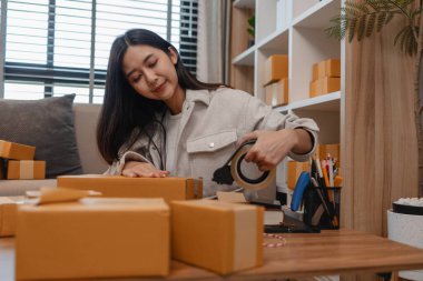 Tüm müşterilere göndermek için paket hazırlıyor. Bu girişimcinin küçük bir işletmesi var. Sme, internetten ürün satıyor.
