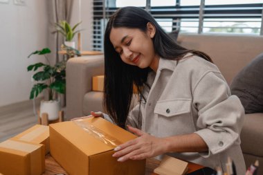 Tüm müşterilere göndermek için paket hazırlıyor. Bu girişimcinin küçük bir işletmesi var. Sme, internetten ürün satıyor.