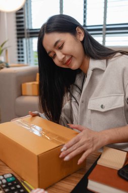 Tüm müşterilere göndermek için paket hazırlıyor. Bu girişimcinin küçük bir işletmesi var. Sme, internetten ürün satıyor.