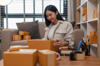 Tüm müşterilere göndermek için paket hazırlıyor. Bu girişimcinin küçük bir işletmesi var. Sme, internetten ürün satıyor.