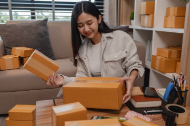 Tüm müşterilere göndermek için paket hazırlıyor. Bu girişimcinin küçük bir işletmesi var. Sme, internetten ürün satıyor.