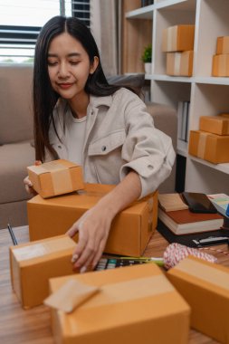 Tüm müşterilere göndermek için paket hazırlıyor. Bu girişimcinin küçük bir işletmesi var. Sme, internetten ürün satıyor.