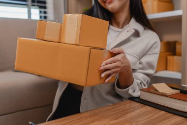 Tüm müşterilere göndermek için paket hazırlıyor. Bu girişimcinin küçük bir işletmesi var. Sme, internetten ürün satıyor.