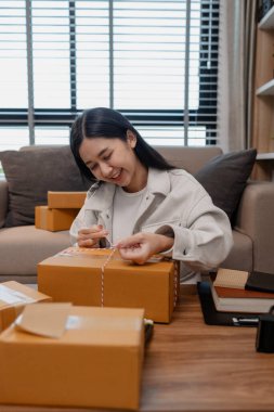 Tüm müşterilere göndermek için paket hazırlıyor. Bu girişimcinin küçük bir işletmesi var. Sme, internetten ürün satıyor.