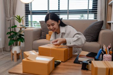 Tüm müşterilere göndermek için paket hazırlıyor. Bu girişimcinin küçük bir işletmesi var. Sme, internetten ürün satıyor.