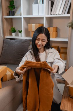 Müşterilere gönderilmek üzere ürünleri memnuniyetle kutulara dolduruyor, bir girişimci alıcılara, paketlere, paketlere, paketlere, küçük işletmelere, hazırlıklara gönderilecek ürünleri hazırlıyor