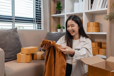 Müşterilere gönderilmek üzere ürünleri memnuniyetle kutulara dolduruyor, bir girişimci alıcılara, paketlere, paketlere, paketlere, küçük işletmelere, hazırlıklara gönderilecek ürünleri hazırlıyor