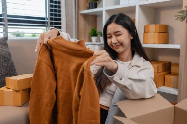 Müşterilere gönderilmek üzere ürünleri memnuniyetle kutulara dolduruyor, bir girişimci alıcılara, paketlere, paketlere, paketlere, küçük işletmelere, hazırlıklara gönderilecek ürünleri hazırlıyor