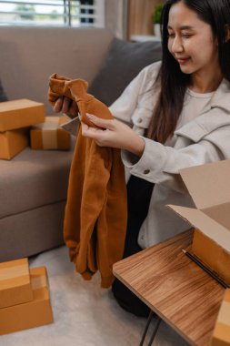 Müşterilere gönderilmek üzere ürünleri memnuniyetle kutulara dolduruyor, bir girişimci alıcılara, paketlere, paketlere, paketlere, küçük işletmelere, hazırlıklara gönderilecek ürünleri hazırlıyor