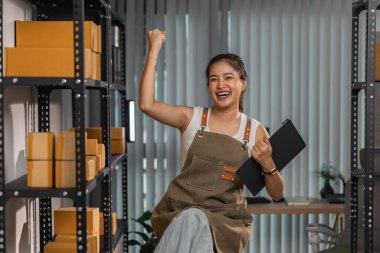 Küçük bir internet işletmesi sahibi, işi başarılı olduğu için kendini çok mutlu hissediyor. Girişimci, depo, paket, küçük işletme, neşe içinde olduğu süre zarfında neşesini gösteriyor.