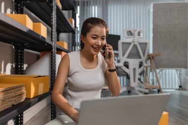 Depodaki paket kutularıyla çalışan bir çalışan depodaki paket kutularının sayısını kontrol eder. Nakliye işindeki bir girişimci depoyu teftiş etmek için gelir.