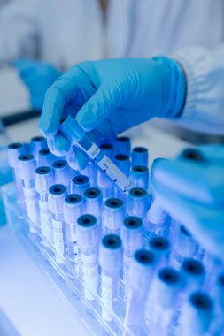 Bir kadın kimyager laboratuvarda çeşitli sıvı bileşiklerini test ediyor, bir bilim adamı bu gelişim üzerine araştırma yapıyor, laboratuvar, test tüpü ve bilimsel ekipmanlarda çalışırken önlük giyiyor.