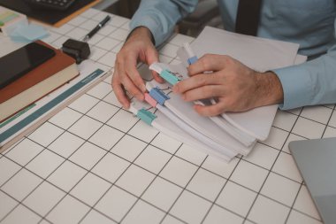 Ofisteki belgelerle bir işadamı ilgileniyor, bir muhasebeci belgeleri topluyor, bir pazarlama müdürü toplantı, finans, girişim, şirket bilgileri hazırlıyor