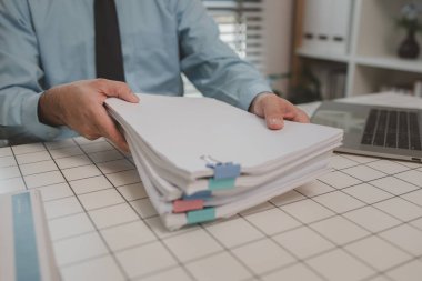 Ofisteki belgelerle bir işadamı ilgileniyor, bir muhasebeci belgeleri topluyor, bir pazarlama müdürü toplantı, finans, girişim, şirket bilgileri hazırlıyor