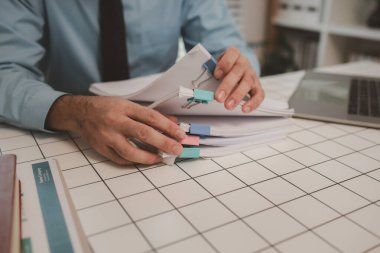 Ofisteki belgelerle bir işadamı ilgileniyor, bir muhasebeci belgeleri topluyor, bir pazarlama müdürü toplantı, finans, girişim, şirket bilgileri hazırlıyor