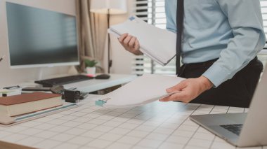 bir işadamı özel ofisinde oturuyor, bir girişimci özenle çalışıyor, baş muhasebeci yöneticilere bir toplantıda sunmak üzere belgeleri ve bütçe rakamlarını gözden geçiriyor