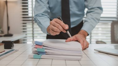 bir işadamı özel ofisinde oturuyor, bir girişimci özenle çalışıyor, baş muhasebeci yöneticilere bir toplantıda sunmak üzere belgeleri ve bütçe rakamlarını gözden geçiriyor