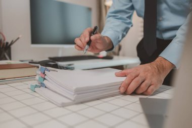 bir işadamı özel ofisinde oturuyor, bir girişimci özenle çalışıyor, baş muhasebeci yöneticilere bir toplantıda sunmak üzere belgeleri ve bütçe rakamlarını gözden geçiriyor