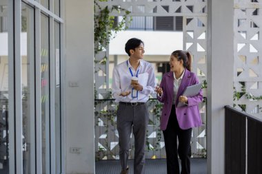 İş adamları şirkette yürürken konuşuyorlar, tüm planlama departmanı personeli toplantıya birlikte yürüyorlar, iş sahipleri ofise yürürken konuşuyorlar.
